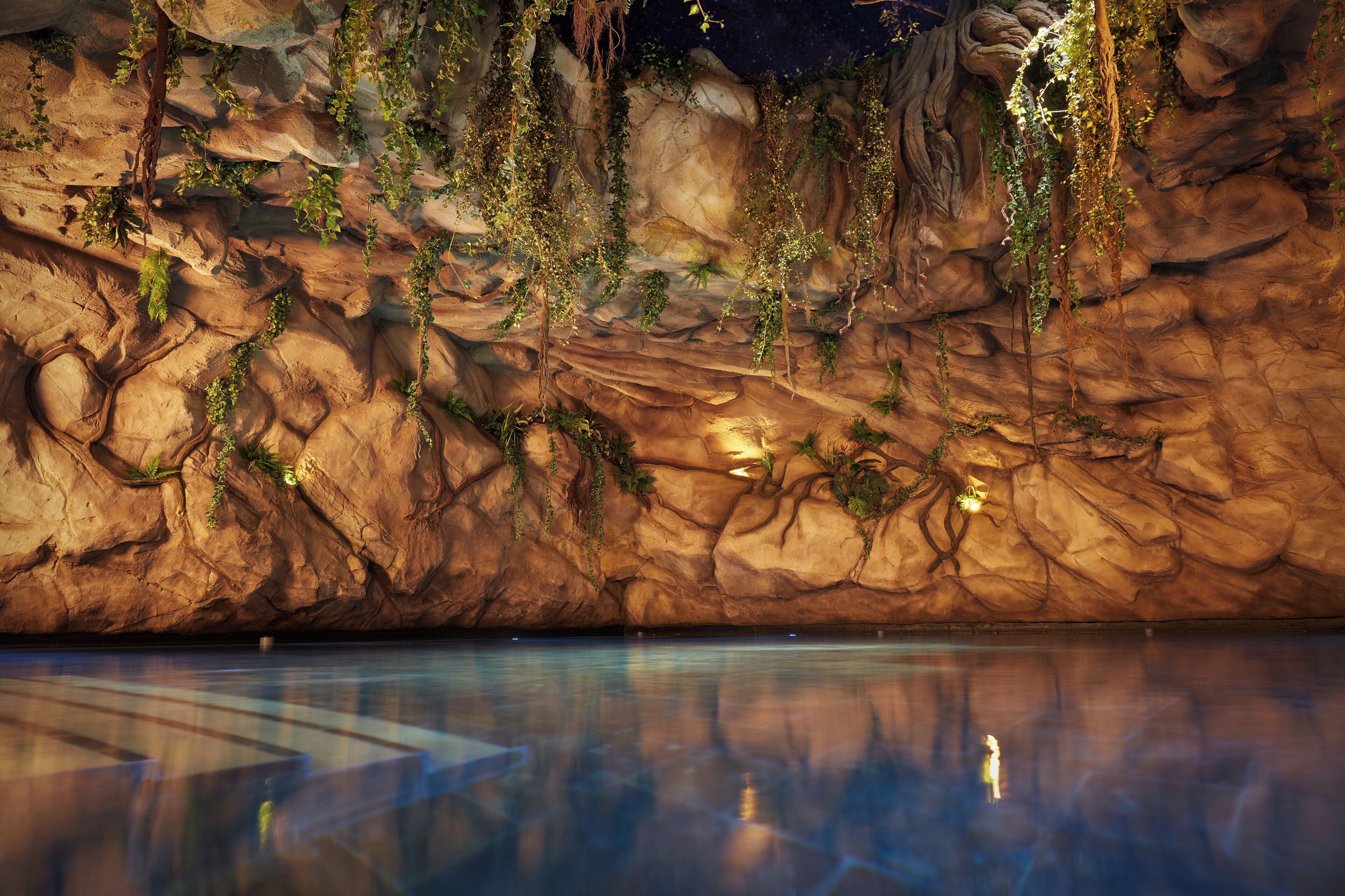 A large indoor pool with clear water reflecting the surroundings.