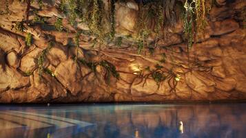 A large indoor pool with clear water reflecting the surroundings.