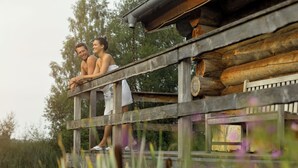 Une terrasse en bois avec, en arrière-plan, un chalet au style rustique.