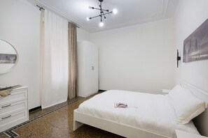A bedroom with a bed, a dresser, a mirror, and a door. - Happy Family Apartment by Wonderful Italy (Genoa)