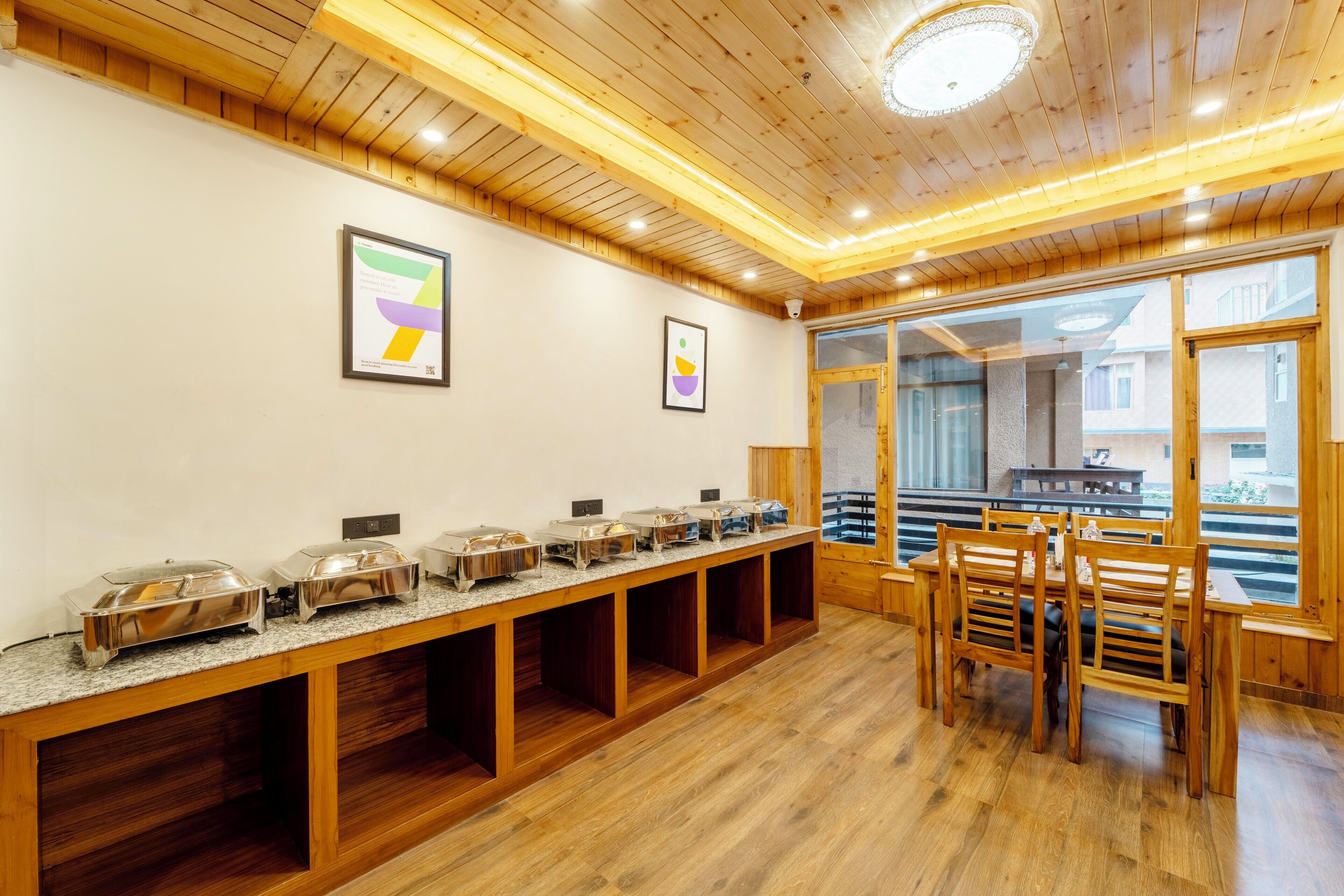 Un buffet disposé avec plusieurs points de service, des panneaux de bois et une vue sur l’extérieur grâce à de grandes fenêtres.