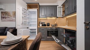 A modern kitchen with grey cabinets, a built-in oven, and a dishwasher.