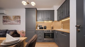 A modern kitchen with grey cabinets, a built-in oven, and a wooden countertop.