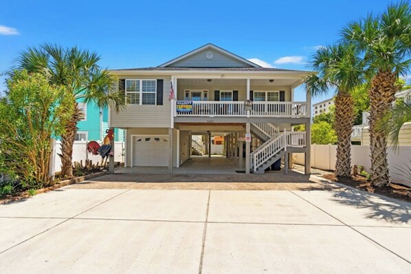 A two-story house with a balcony, a garage, and a front porch.