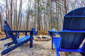 A forested area with outdoor seating including Adirondack chairs and a fire pit. - Private Home in Egg Harbor-Sleeps 13 with Fire pit (Egg Harbor)