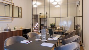 A modern conference room with a long table, chairs, a laptop, and a pitcher of water. - Decòncept House (Rome)