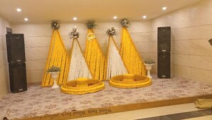 A spa area with a massage bed, a small potted plant, and a decorative wall with yellow and white elements. - Hotel Grand Empire (Agra)