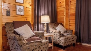 Een gezellige kamer met twee gestreepte fauteuils, een klein tafeltje en een lamp.