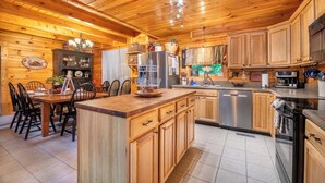 Een houten blokhut interieur met een eethoek, keuken en inbouwmeubels.