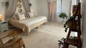 A bedroom with a bed, a nightstand, a chair, a wooden ladder, and a potted plant. - Villa in Ménerbes in the Luberon golden triangle (Ménerbes)