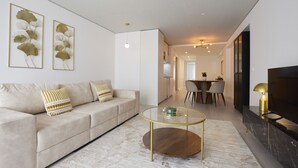 A modern living room with a sofa, coffee table, and artwork on the wall.