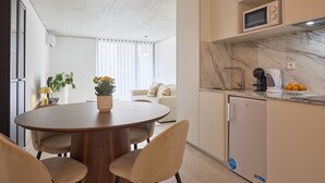 A modern kitchen with a built-in microwave, a coffee maker, and a small refrigerator.