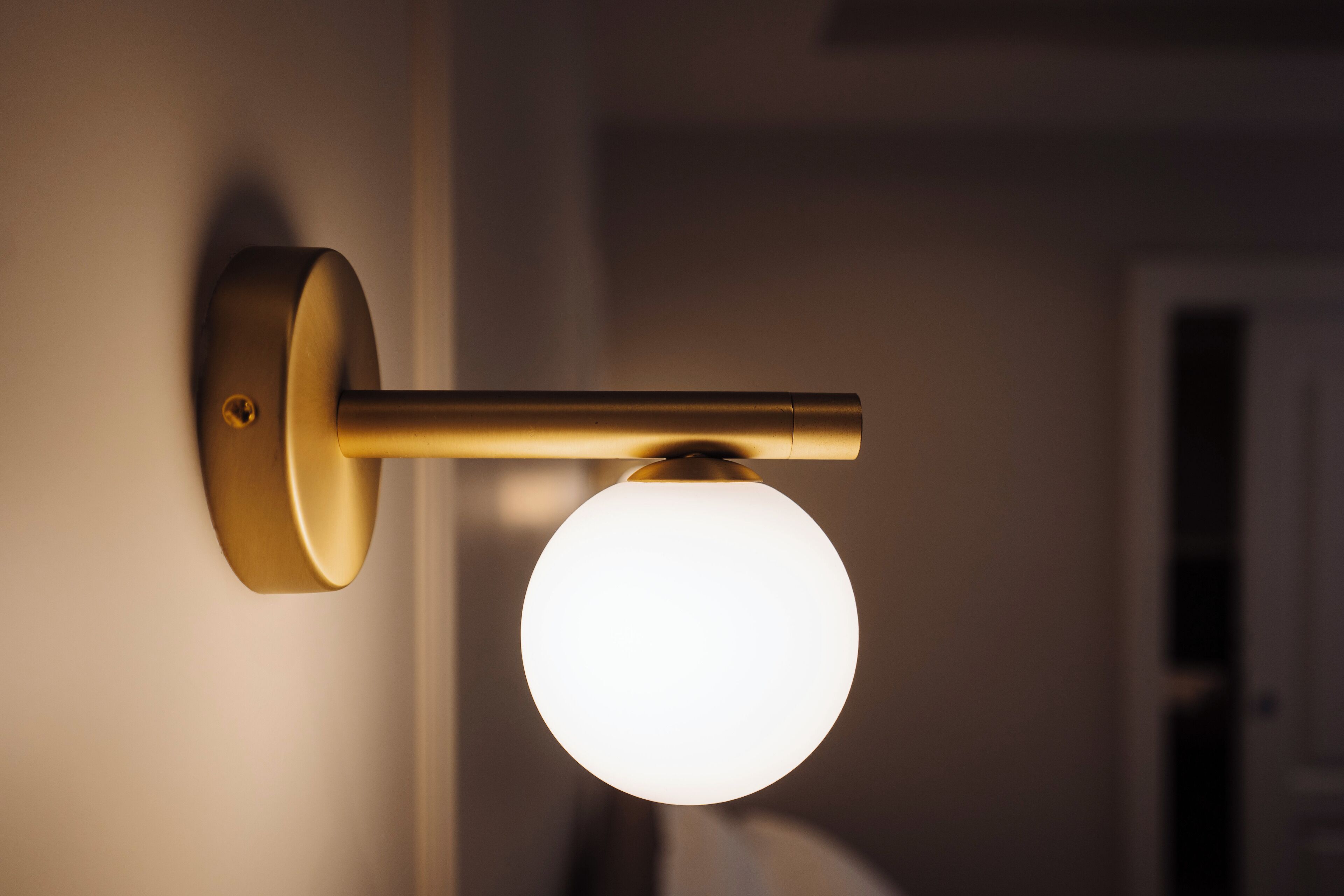 A wall-mounted light fixture with a spherical glass shade.