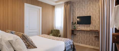 A bedroom with a bed, a television, a chair, and a shelf.