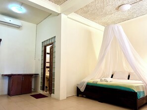 A bedroom with a bed under a canopy, a wooden cabinet, and a tiled floor. - Arys Lagoon Resort Karimunjawa (Karimunjawa)
