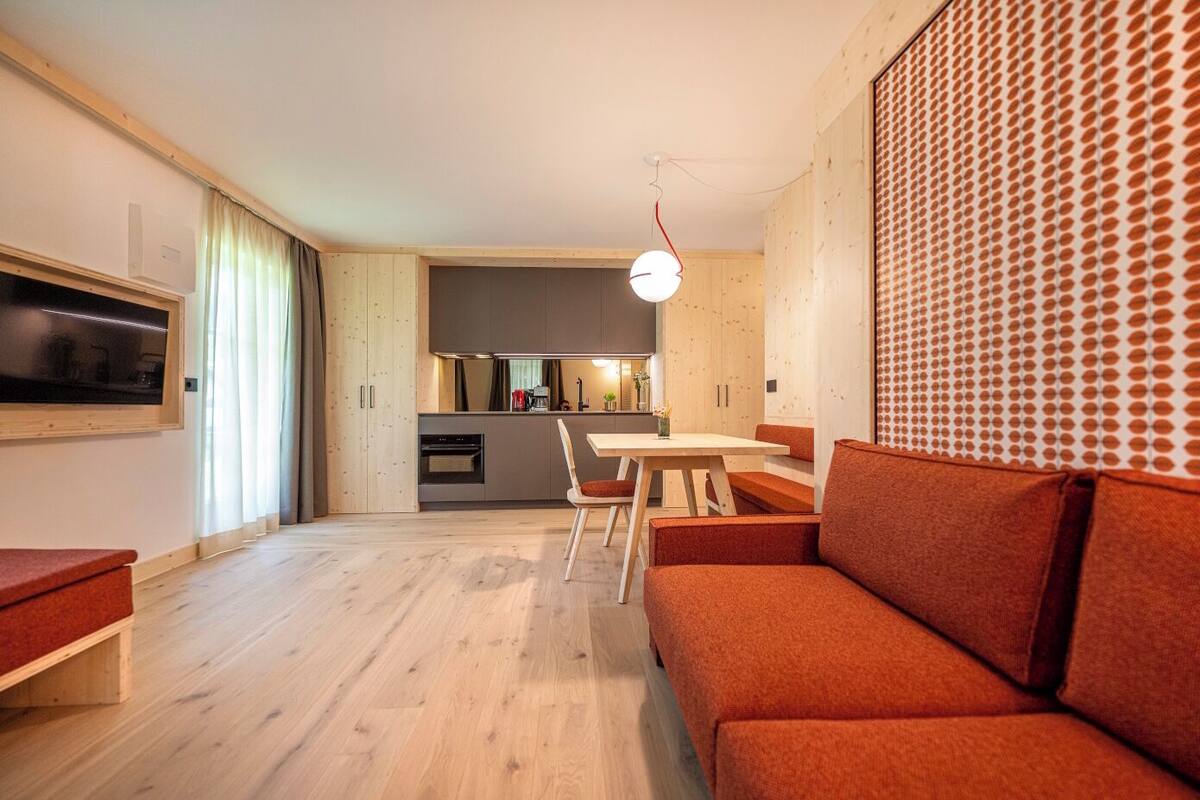 Un salon moderne avec un canapé, une table à manger et une cuisine en arrière-plan.