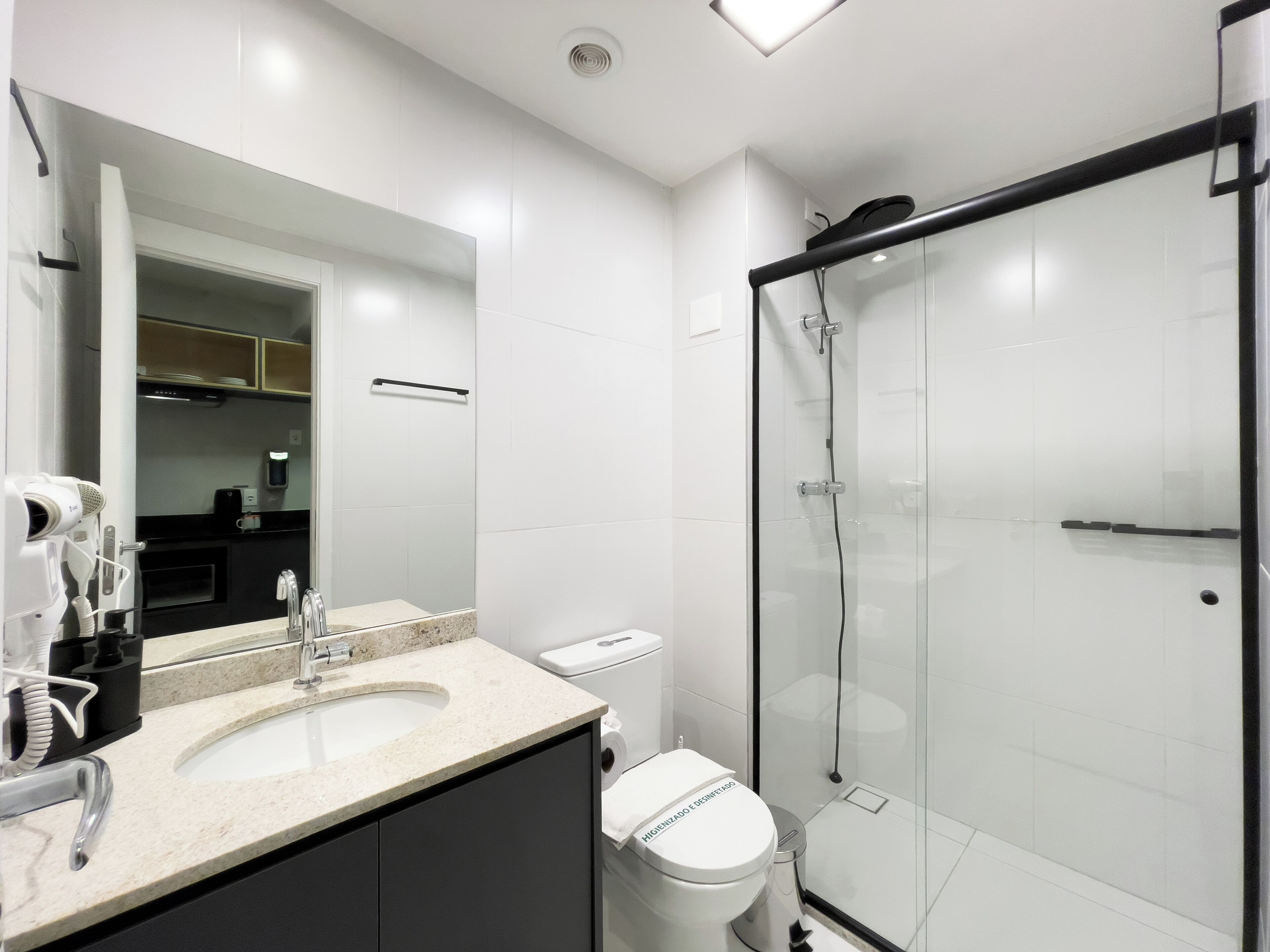 A modern bathroom with a glass-enclosed shower, a sink with a countertop, and a toilet.