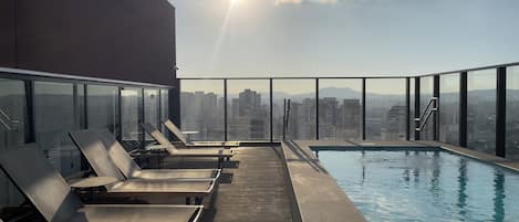 حمّام سباحة خارجي، مظلات على حمّام السباحة، مقاعد للتشمس