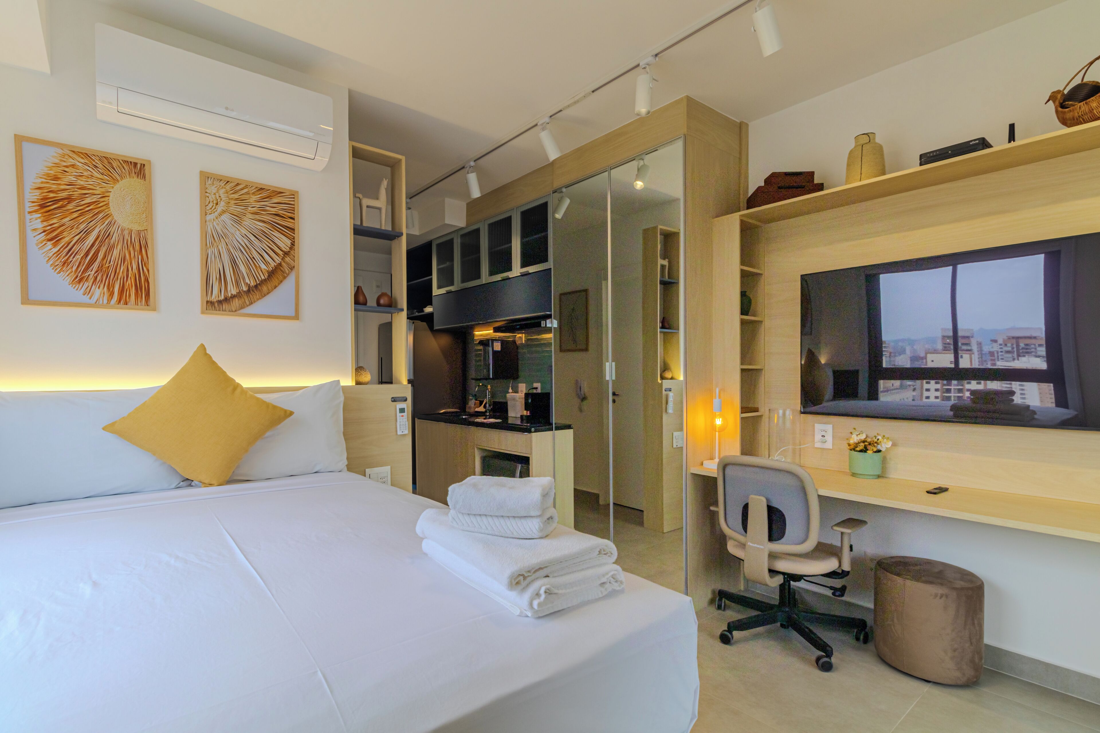 Una habitación de hotel moderna con una cama, un escritorio y vista a la ciudad.