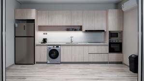Une cuisine moderne équipée d’un lave-linge, d’un four et d’un four à micro-ondes intégrés.
