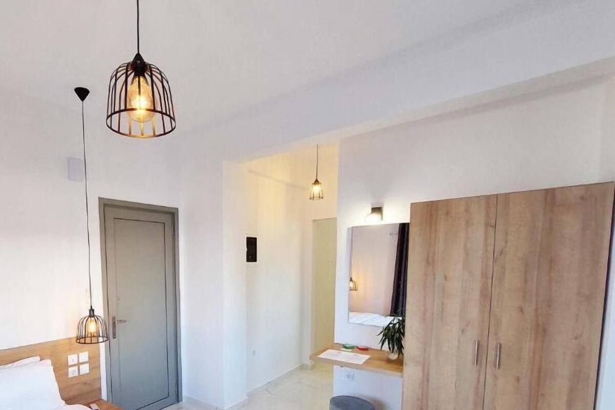 Une chambre d’hôtel avec un lit, une armoire, un bureau et un miroir.