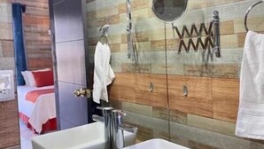 A modern bathroom with two rectangular sinks, a mirror, a towel rack, and a shower area. - HOTEL PINEDA REAL  (Tonalá)