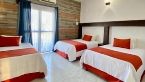 A hotel room with three beds, a wooden wall, an air conditioning unit, and a large window with curtains. - HOTEL PINEDA REAL  (Tonalá)