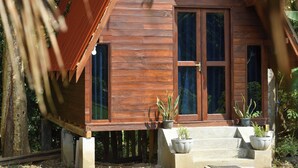 Una casa de madera con porche y plantas en macetas.