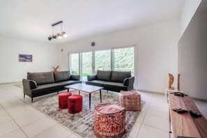 Appartement Confort, vue fleuve | Coin séjour | Télévision à écran plat de 65 pouces avec chaînes numériques