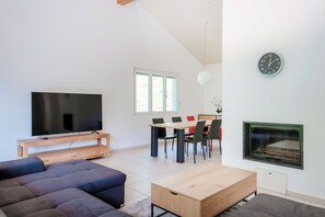 Appartement Deluxe, patio, vue fleuve | Coin séjour | Télévision à écran plat de 65 pouces avec chaînes numériques