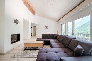 Departamento Deluxe, patio, vista al río | Área de sala de estar | Televisión de pantalla plana de 65 pulgadas con canales digitales 
