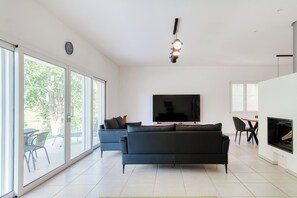 Appartement Confort, vue fleuve | Coin séjour | Télévision à écran plat de 65 pouces avec chaînes numériques