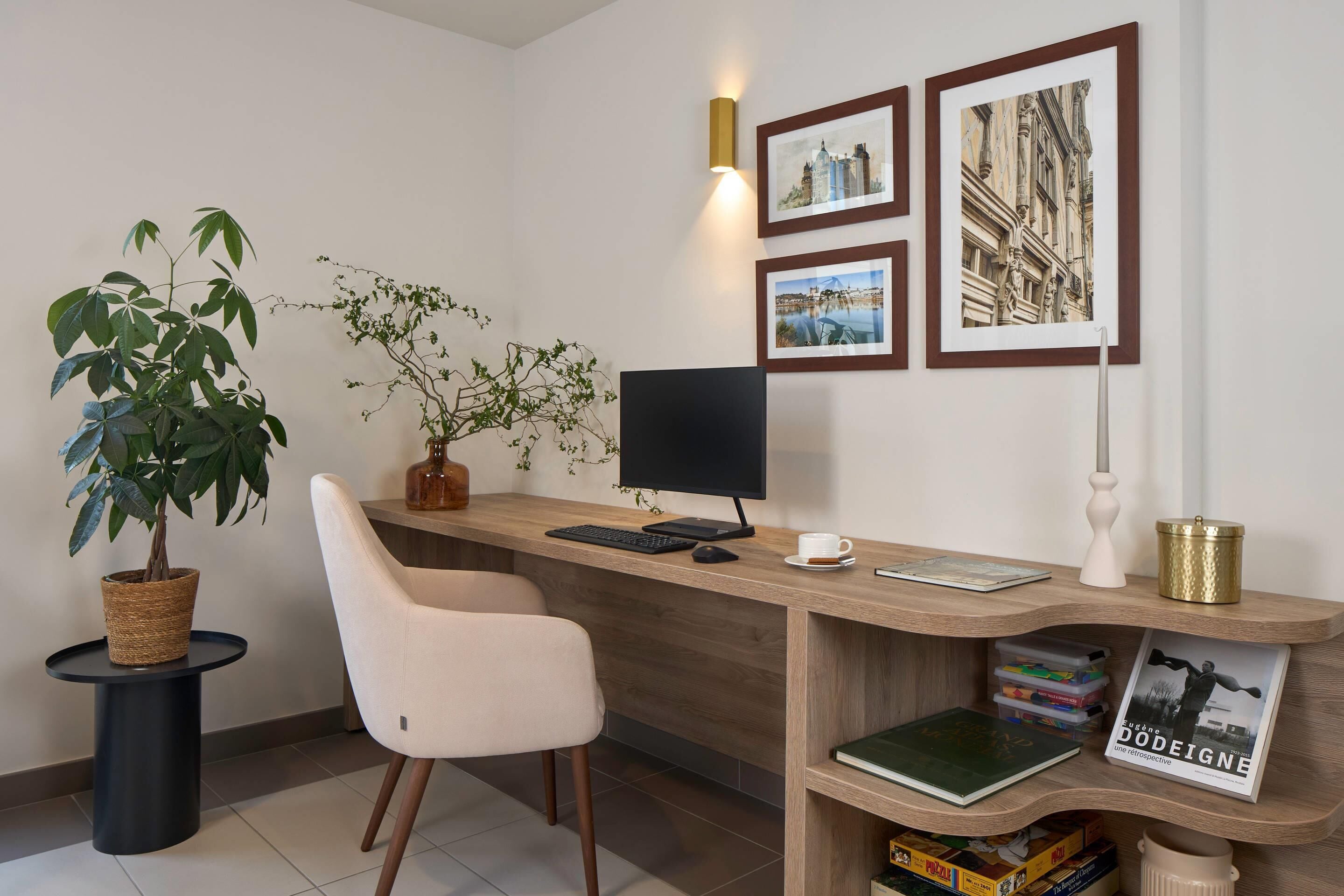 A modern office desk with a computer, a chair, and a potted plant.