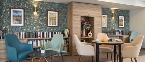 Un espace détente moderne comprenant une bibliothèque, des sièges et une table basse.