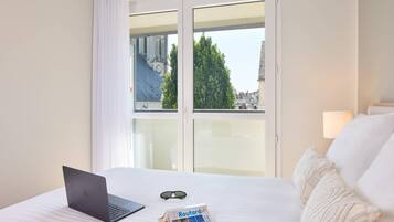 Une chambre d’hôtel avec un lit, un ordinateur portable et un magazine posé sur le lit.