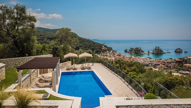 A swimming pool with a view of a coastal town and mountains. - Elysium Living Parga (Parga)
