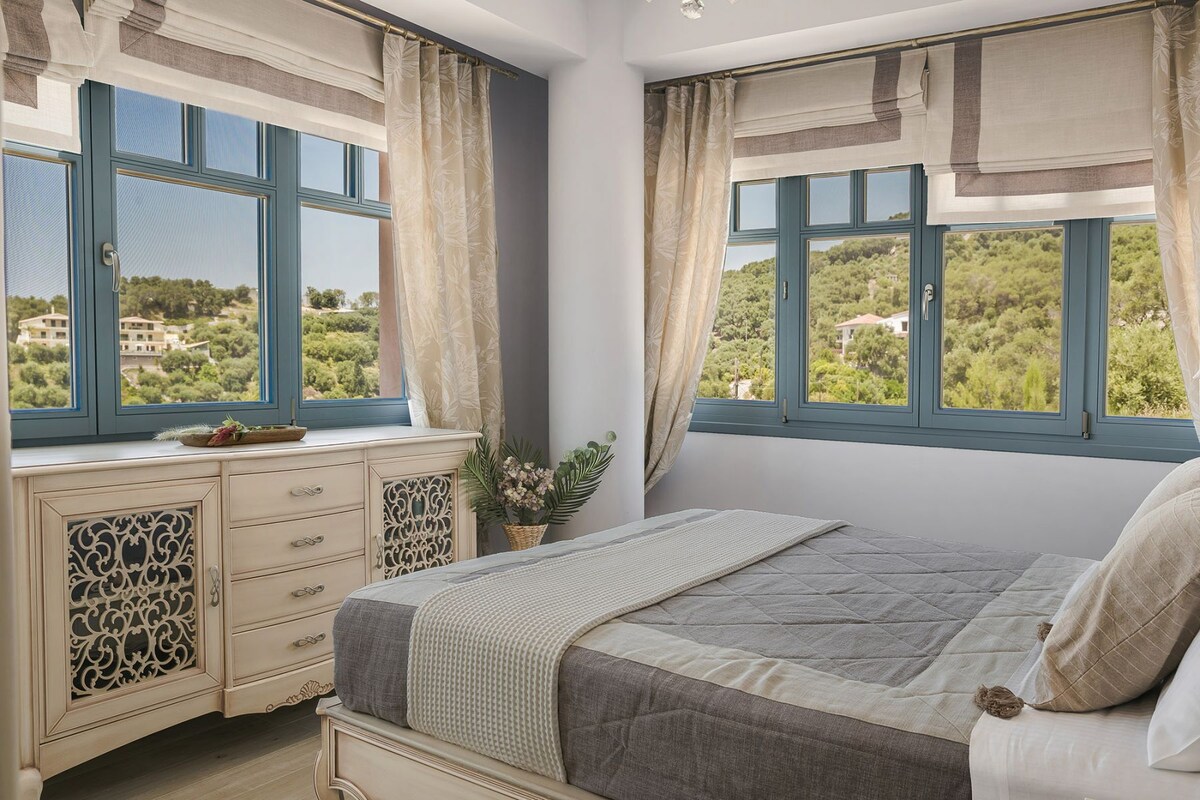 A bedroom with a bed, a dresser, and a window with a view of greenery.