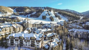 A snow-covered resort with multiple buildings, ski slopes, and forested mountains in the background. - Slopeside Townhome in Beaver Creek | Chalet Montsor (Beaver Creek)