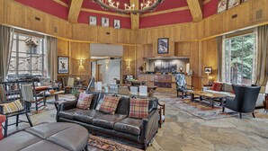 A spacious lobby with a leather sofa, wooden furniture, and a stone floor. - Slopeside Townhome in Beaver Creek | Chalet Montsor (Beaver Creek)