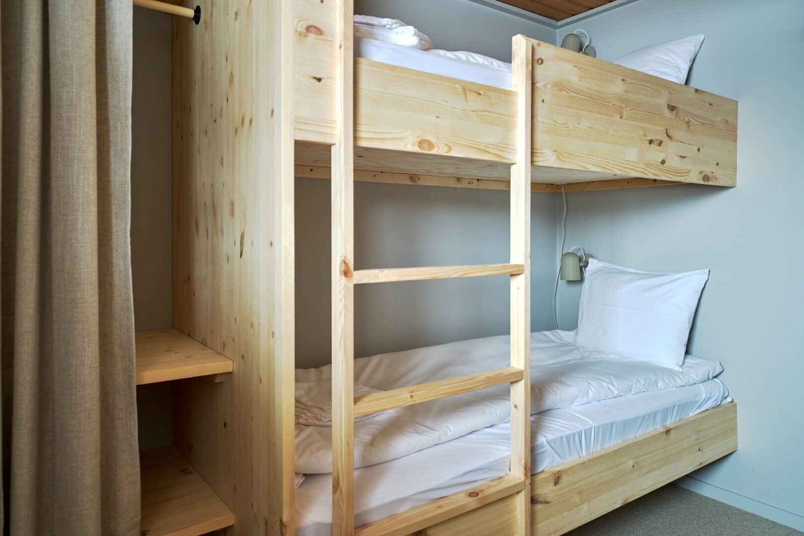 A bunk bed with two levels, each with a pillow and a headboard.