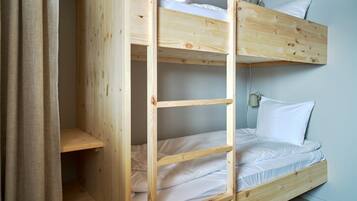 A bunk bed with two levels, each with a pillow and a headboard.