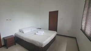 Une chambre à coucher avec un lit, une table de chevet, une armoire en bois et une porte.
