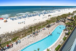 Ein Strandresort mit Schwimmbad, Strandsonnenschirmen und einem Steg im Hintergrund.