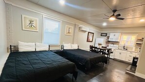 A room with two beds, a small kitchenette, and a ceiling fan. - Madison gate studio (Goldsboro)