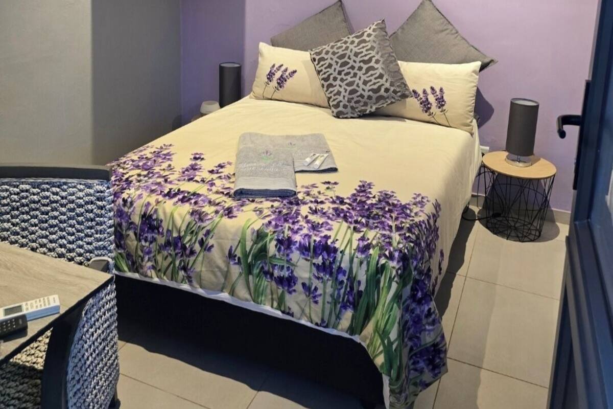 Un dormitorio con cama, televisión y obras de arte en la pared.