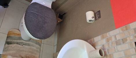 Een badkamer met toilet, bidet en wastafel.