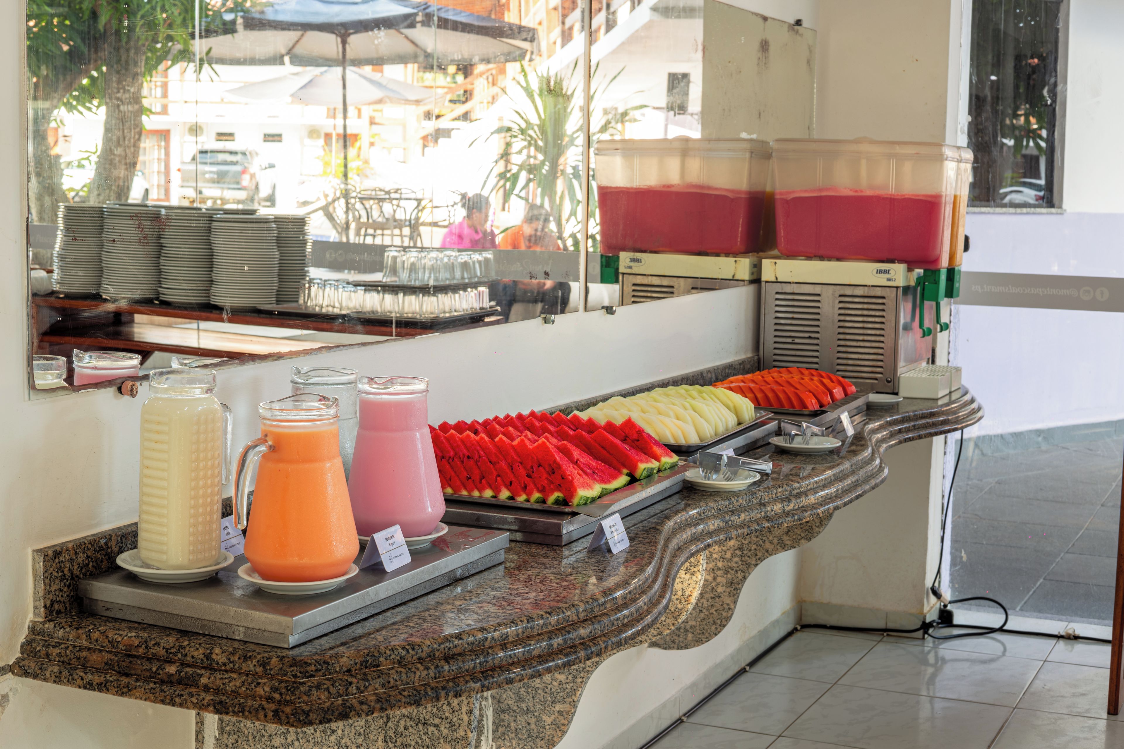 A buffet counter with various food items and beverages.