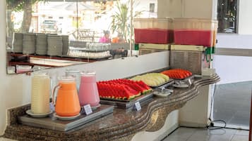 A buffet counter with various food items and beverages.