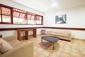 Un salon spacieux comprenant un canapé, une table basse, un bureau et un tableau accroché au mur.