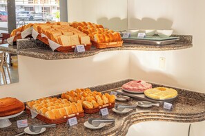 Un buffet proposant une variété de pains et un plat de viande.